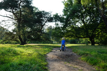 Obraz premium Child biking in the woods
