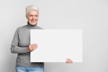 Elderly woman presenting a blank white board