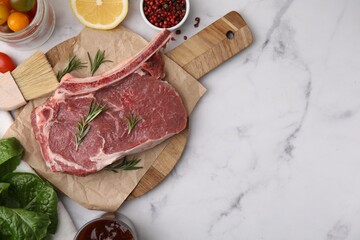 Flat lay composition with raw meat, rosemary and products on white marble table. Space for text