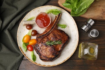 Tasty grilled meat, rosemary, tomatoes and marinade on wooden table, flat lay