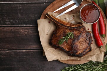 Tasty grilled meat, rosemary, marinade and chili on wooden table, top view. Space for text