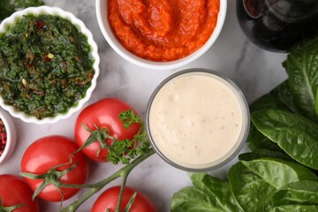Different marinades and products on white marble table, flat lay