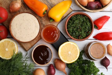 Different fresh marinades and ingredients on white wooden table, flat lay
