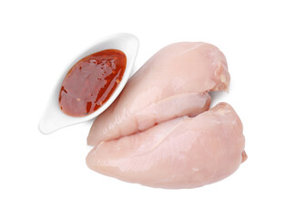 Marinade, basting brush, raw chicken fillets and chili peppers isolated on white, top view