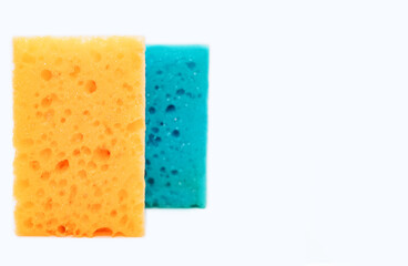 Sponges for washing dishes in the kitchen isolated on a white background with free space for text. New yellow and blue kitchen sponge for cleaning close-up. Cleaning concept