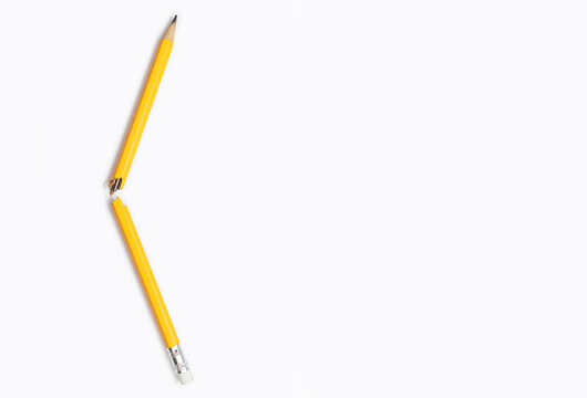 Broken pencil on white background close-up and free space for text. Graphite yellow pencil, broken in the middle, a manifestation of emotions, stress, aggression, problems in studies, problems at work - Powered by Adobe