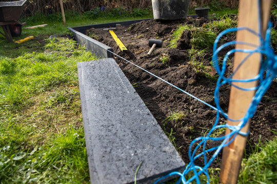 Eine Fl&auml;che im Garten vermessen um Bordsteine zu setzen