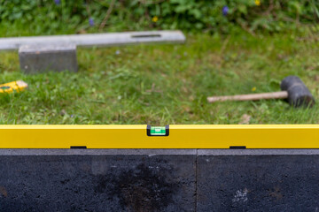 Eine Wasserwage um Bordsteine gerade auszurichten