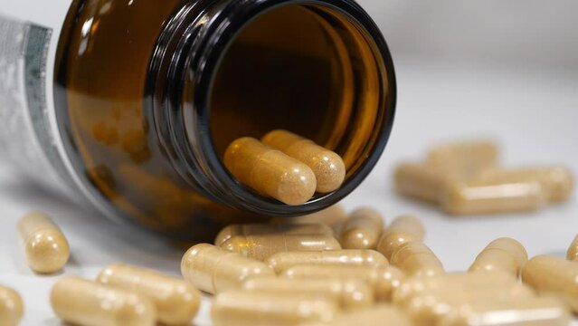 Pharmaceutical substance, drug treatment, harm from medications. Overdose or poisoning, high doses, side effects. Pharmacological biochemistry, drug therapy. Capsules and glass jar lies on table