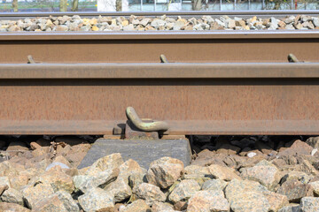 brown train track viewed from the side which is mounted on a sleeper.