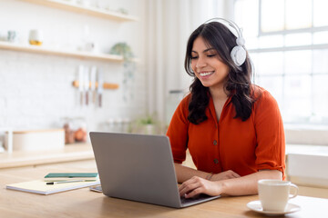 Engaged middle eastern woman with headphones and laptop