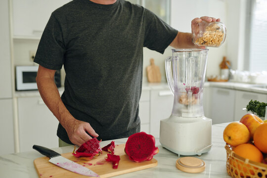 Cropped image of man making granola passion fruit smoothie