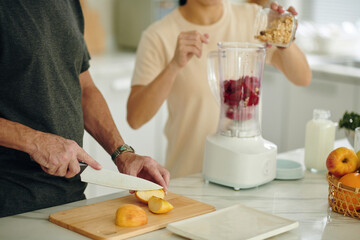 Man cutting apples for breakfast smoothie - 786575582