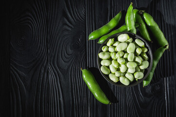 fresh greens broad beans fava on a dark background