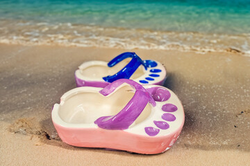Fototapeta na wymiar Ceramic ashtray in the shape of a flip flop by the sea. Tourism.Vacation Concept