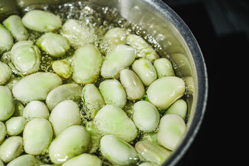 fresh greens broad beans fava boiled on a dark background