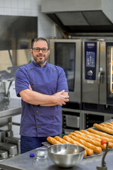 Professional man baker baking French baguette bread