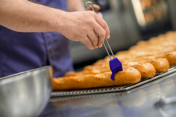 Unrecognizable man baker baking French baguette bread