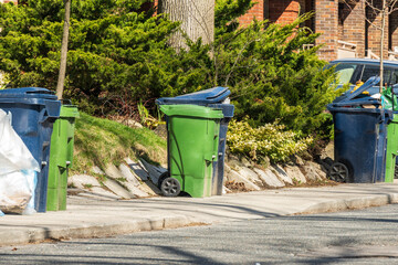 green economy: recycling bins and a compost bin waiting for collection on a residential street shot...
