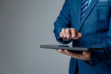 businessman in blue suit using tablet