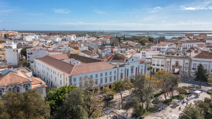 Fototapeta na wymiar Traditional Portuguese town of Faro on oceanfront with old architecture, filmed by drone. Arco de villa and largo de se.