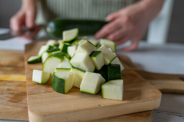 Chopped and  cubed raw  zucchini or green squash on a cutting board in the kitchen