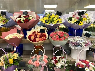 composed bouquets of exotic flowers in wrapping paper and in baskets on the background of mirrored walls in a flower shop