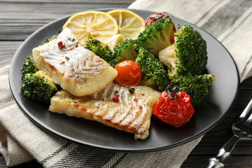 Tasty cod cooked with vegetables served on table, closeup