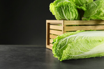 Fresh ripe Chinese cabbages and wooden crate on grey table, space for text - obrazy, fototapety, plakaty