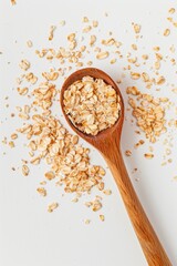 A wooden spoon filled with oatmeal on a white surface. Perfect for food and nutrition concepts - obrazy, fototapety, plakaty