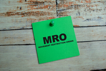 Concept of MRO - Movement Restriction Order write on sticky notes isolated on Wooden Table. - obrazy, fototapety, plakaty