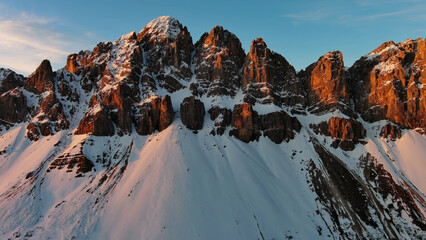 Rocky snow mountains at sunrise aerial