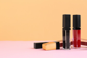 Many different lip glosses on color background, space for text