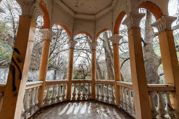 Vintage veranda and abandoned balcony with classical architecture and early spring view.