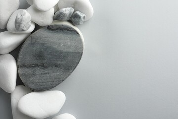 Presentation for product. Stone podium and pebbles on light grey background, top view. Space for...