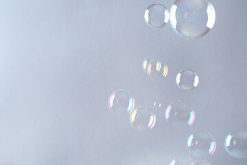 Beautiful transparent soap bubbles on gray background, space for text