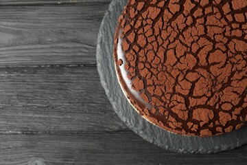 Delicious chocolate truffle cake on black wooden table, top view. Space for text