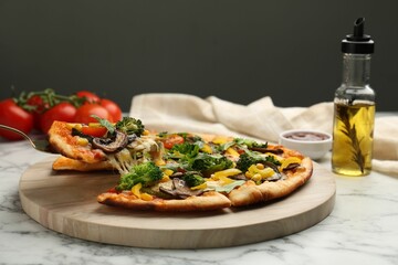 Taking piece of delicious vegetarian pizza at white marble table, closeup