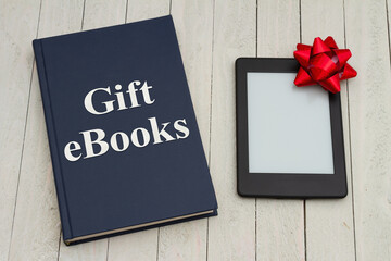 Retro old blue book on a desk with an ereader with gift bow - 786607342
