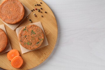 Vegetarian product. Uncooked carrot cutlets and ingredients on light wooden table, top view. Space for text
