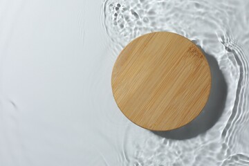 Presentation of product. Wooden podium in water on white background, top view. Space for text