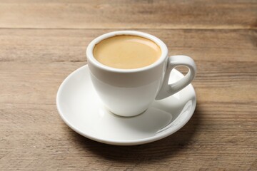 Aromatic coffee in cup on wooden table