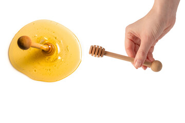 Honey dipper in woman hand isolated on a white background. - obrazy, fototapety, plakaty