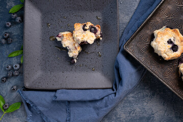 Freshly baked blueberry biscuits, scones, blue napkin and background, antique baking pan.  Berries...