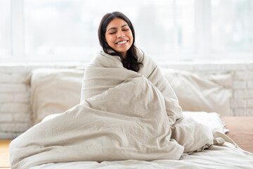 Woman wrapped in a blanket with a happy face - Powered by Adobe