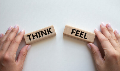 Think or Feel symbol. Concept word Think or Feel on wooden blocks. Businessman hand. Beautiful...