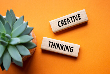 Creative thinking symbol. Wooden blocks with words Creative thinking. Beautiful orange background...