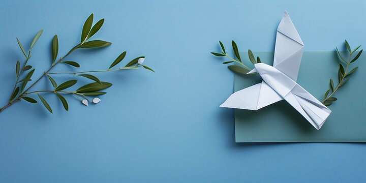 Paper origami dove with olive branch on blue background, blank space for text. Concept of peace and unity
