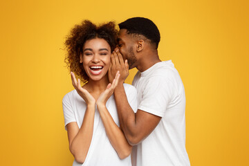 Black man sharing secret with his girlfriend