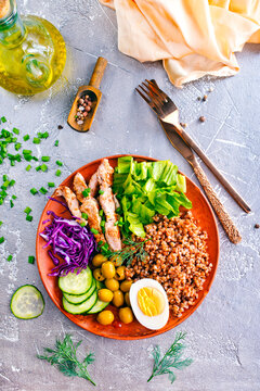 Boiled buckwheat or porridge with chicken for breakfast, cooked salted eggs, vegetables and fresh greens